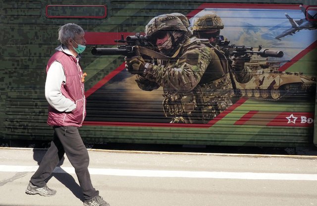 Пешеходец минава покрай военен плакат на жп гара в Санкт Петербург
