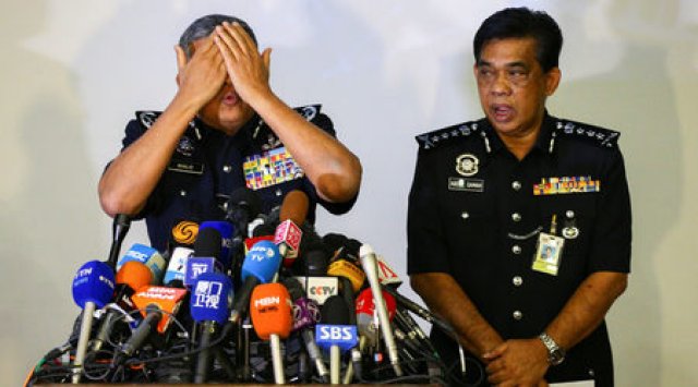 Халид Абу Бакар, началник на полицията на Малайзия, демонстрира на журналисти как е била втрита отровата по лицето на жертвата.