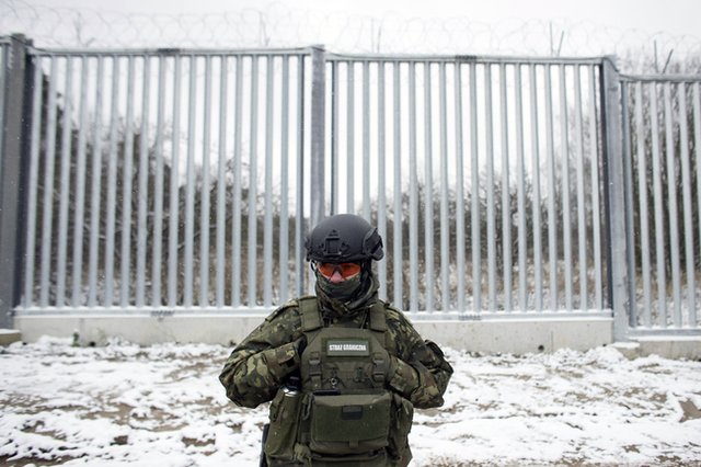 Полски граничар пред оградата по границата между Полша и Беларус. Снимка: АП