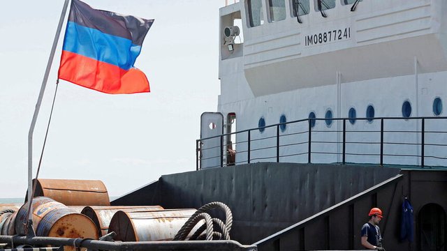 Листове стомана са натоварени на този кораб в пристанището на Мариупол, над който се вее знамето на непризнатата донецка република. © Reuters