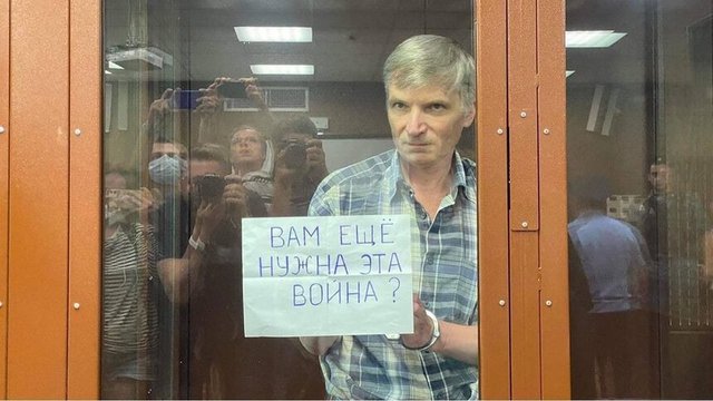 Алексей Горинов показва по време на съдебното заседание надпис "Още ли ви е необходима тази война?". Той е първият осъден на затвор по нов закон срещу дескредитирането на армията, приет след началото на войната в Украйна. © Facebook/Константин Янкаускас