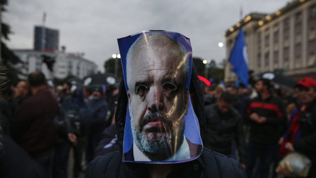 Демонстрант носи маска с лицето на албанския премиер Еди Рама. © Associated Press