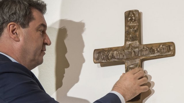 Маркус Зьодер поставя дървен кръст в офиса си. Сн. АР